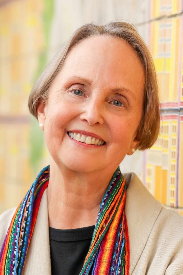 A woman with long hair and a colorful necklace.